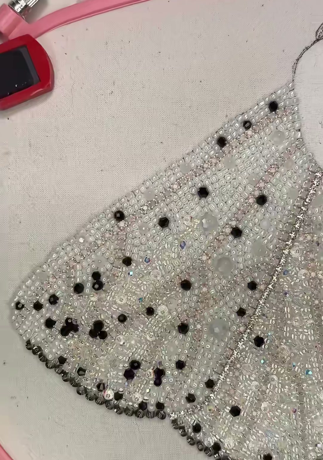 Step 13 — A dense close-up of the completed wing, showing the packed silver seed-bead surface and scattered black spots