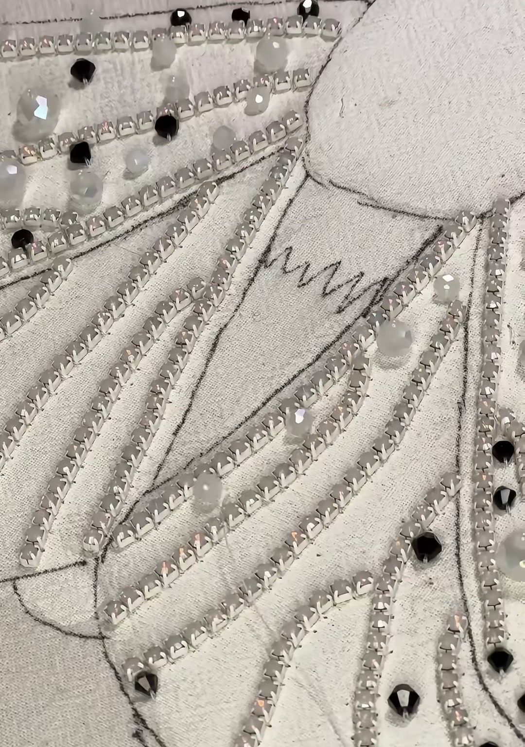 Step 06 — White and clear rhinestones placed among the silver beads, catching the light like dewdrops on wings