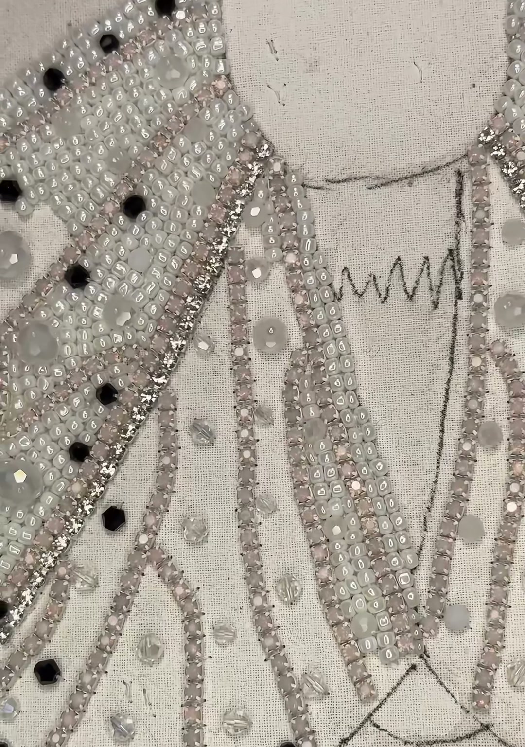Step 10 — A tight close-up of the beaded wing surface, showing the mix of silver seed beads, black crystals, and clear rhinestones