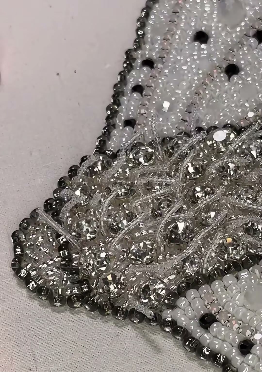 Step 17 — A close-up of the abdomen showing grey bugle beads, clear crystals, and the neat segmentation of the moth body
