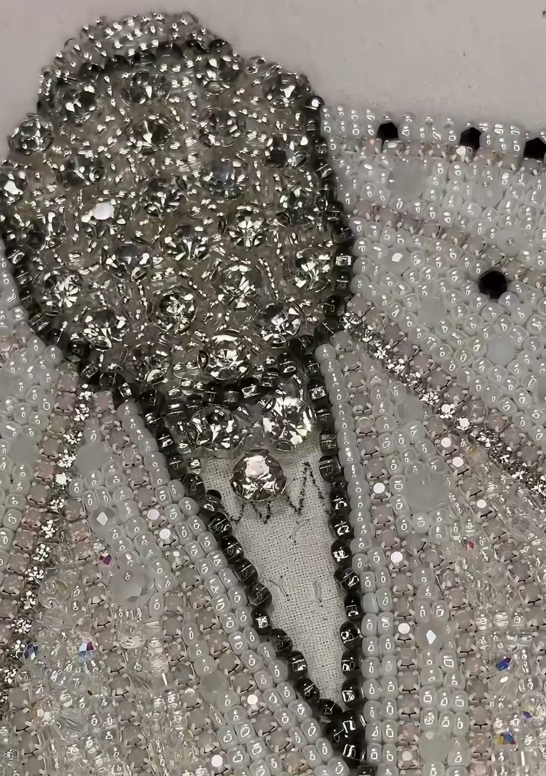 Step 15 — A side view of the moth body showing the layered silver and gold beadwork along the abdomen