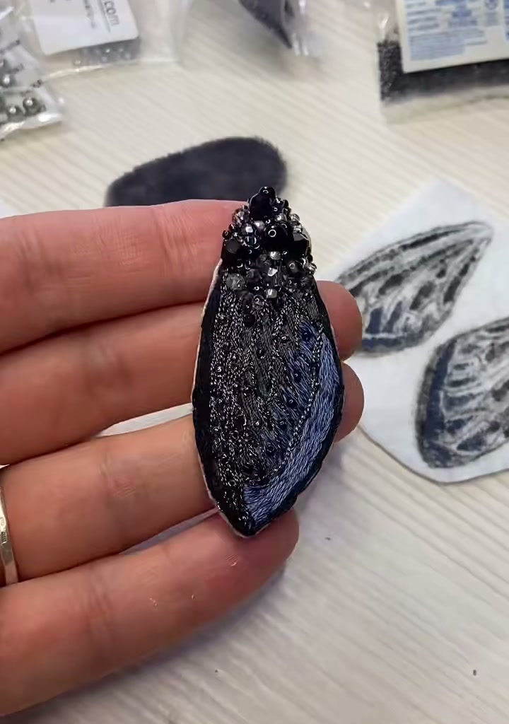 Step 04 — Close-up of the felt body, now fully encrusted with black rhinestones and seed beads, taking on a sculpted three-dimensional form