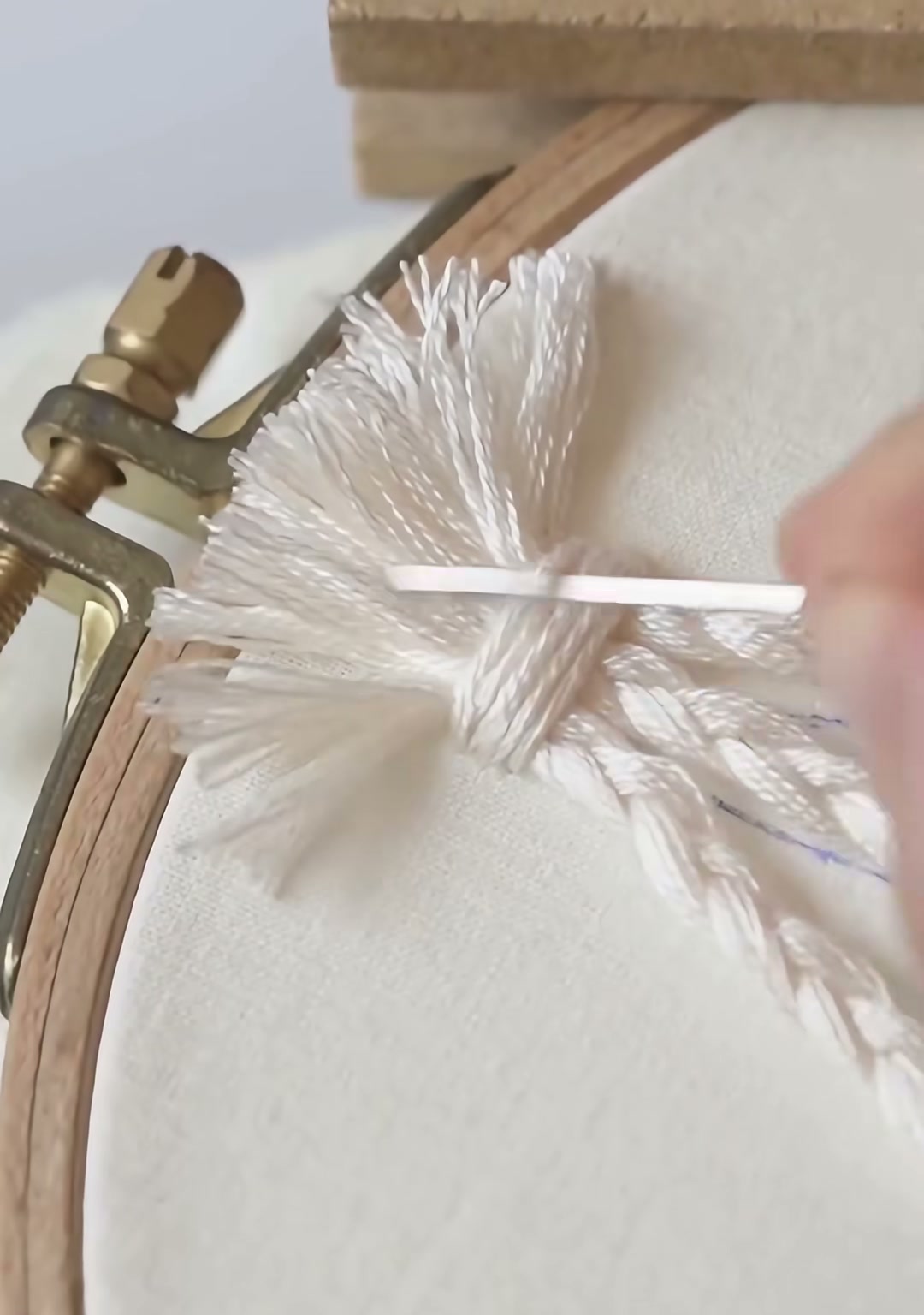 Step 06 — The basket edge is outlined in tan, and a small white tassel hangs from the bottom