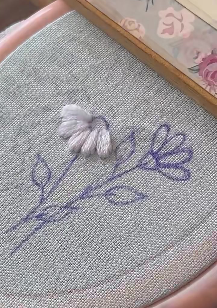 Needle beginning the first petal on the second drawn daisy