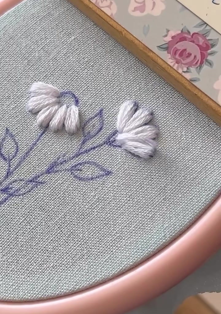 Golden-brown thread beginning to fill the center of the first daisy