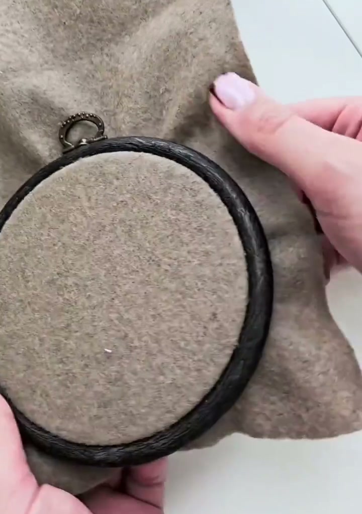 Step 01 — A round dark wooden embroidery hoop backed with brown felt