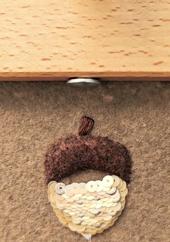 Step 14 — The lower acorn fully covered in overlapping cream sequins