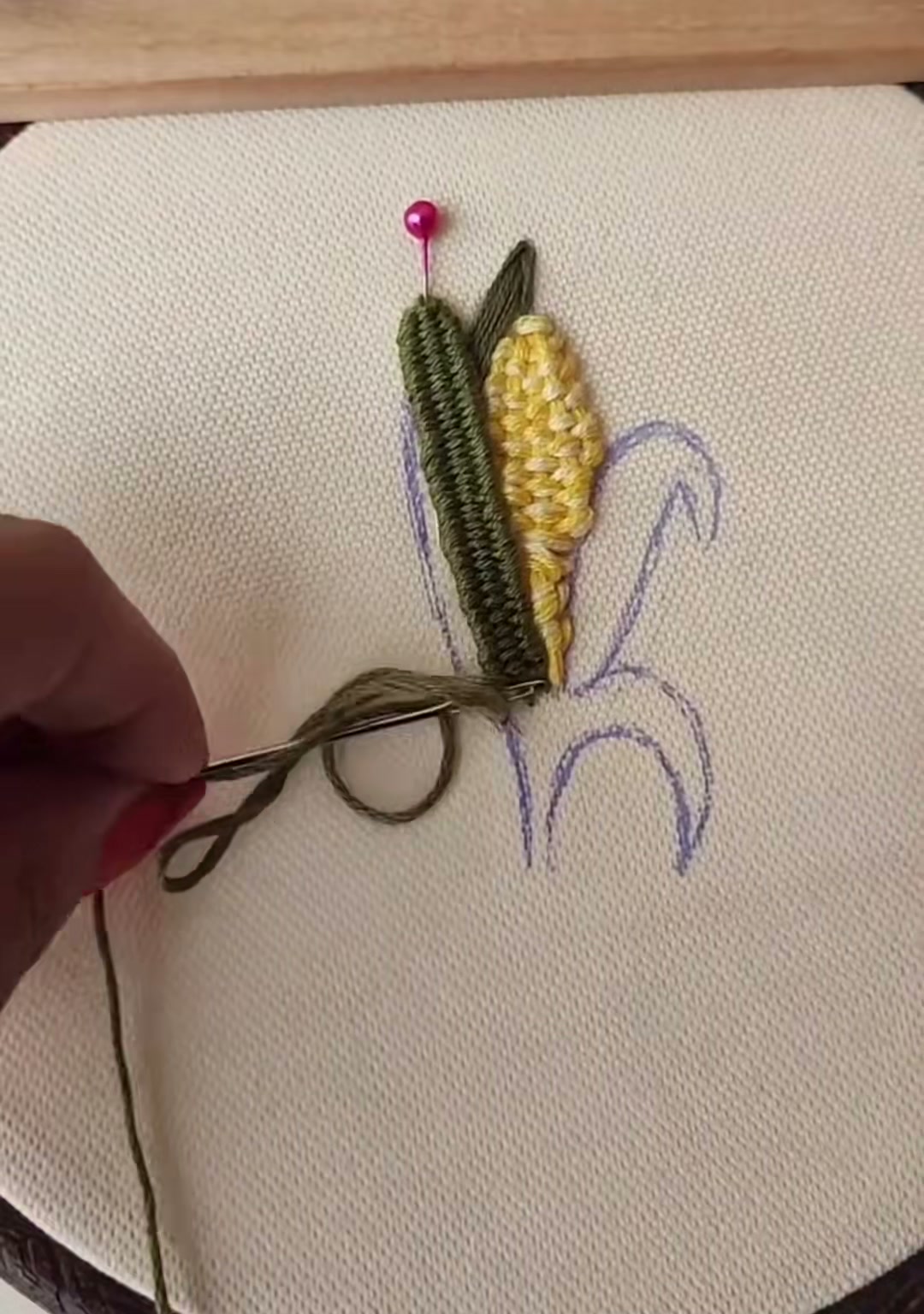 Step 12 — Both green husks complete, cupping the yellow corn ear between them