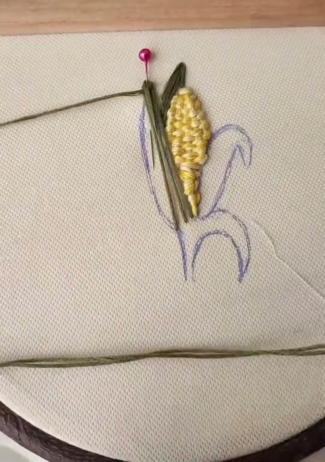 Step 10 — One full green husk completed, framing the yellow corn on one side