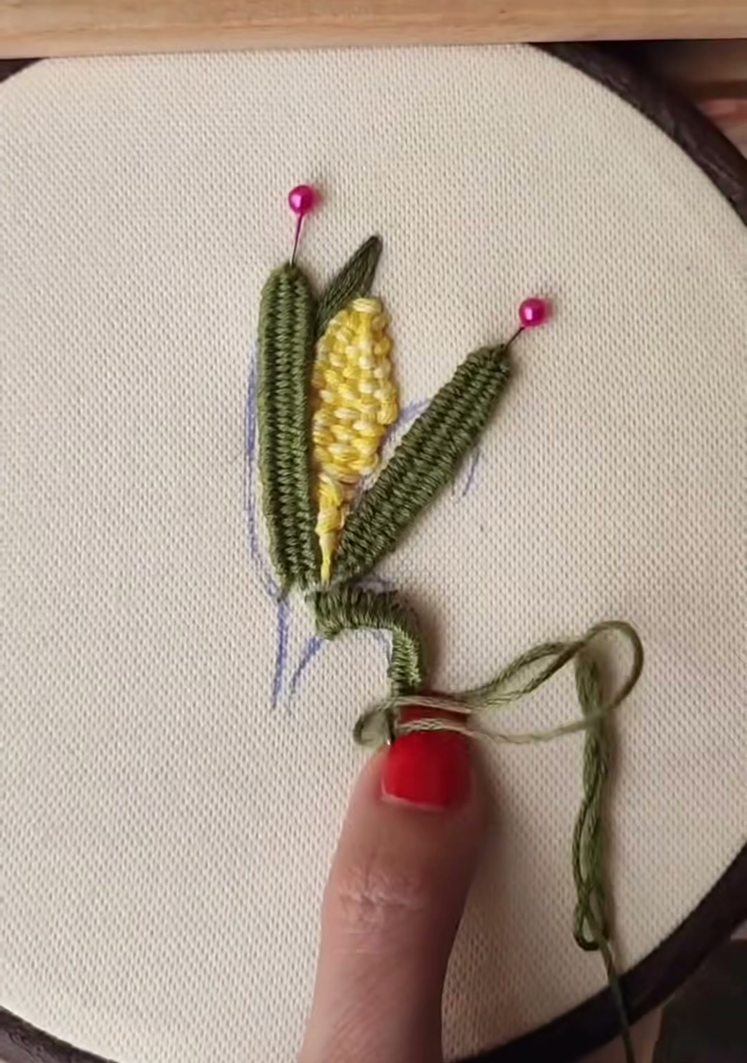Step 14 — The completed embroidered corn in the hoop, showing raised yellow kernels and deep green husks