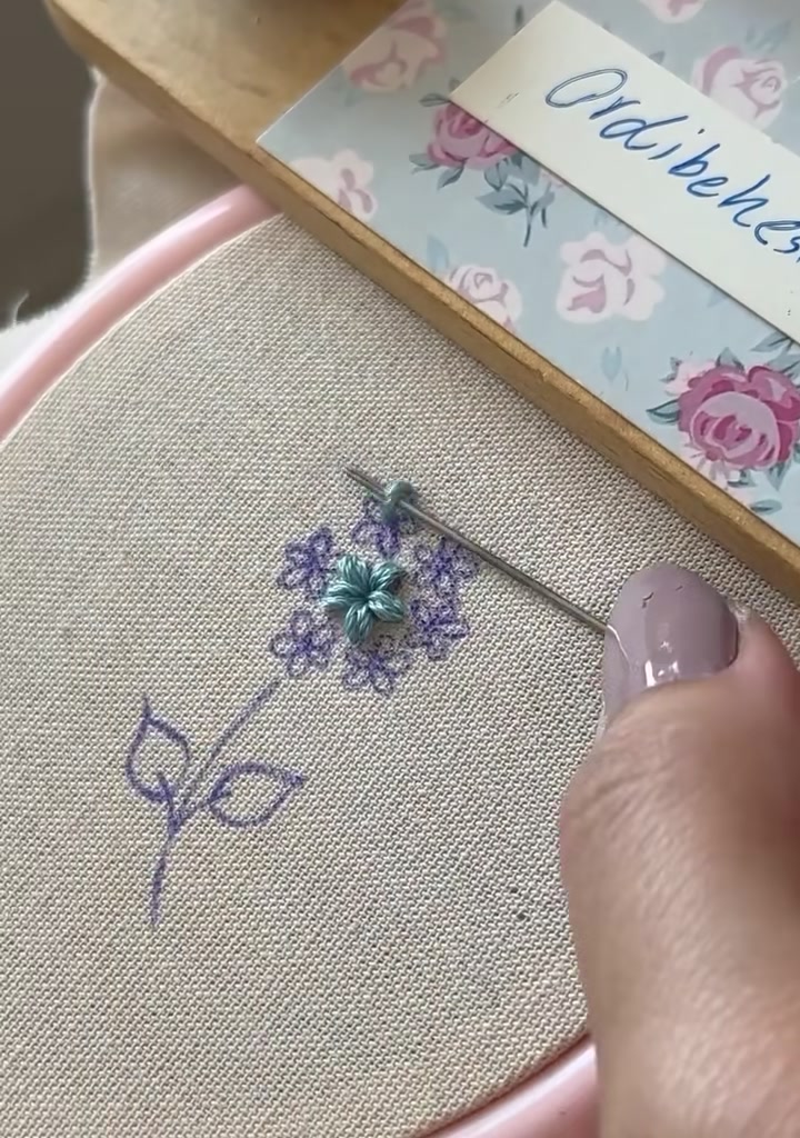 Two completed star flowers side by side in the embroidery hoop