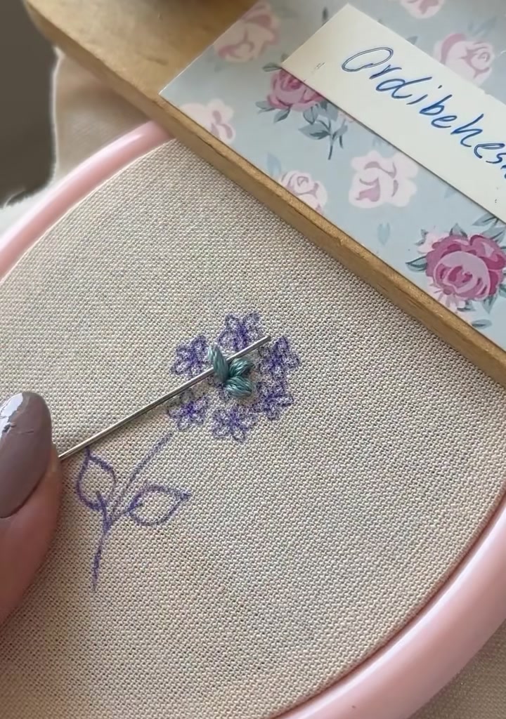 Needle adding the first stitch of the second star flower next to the first