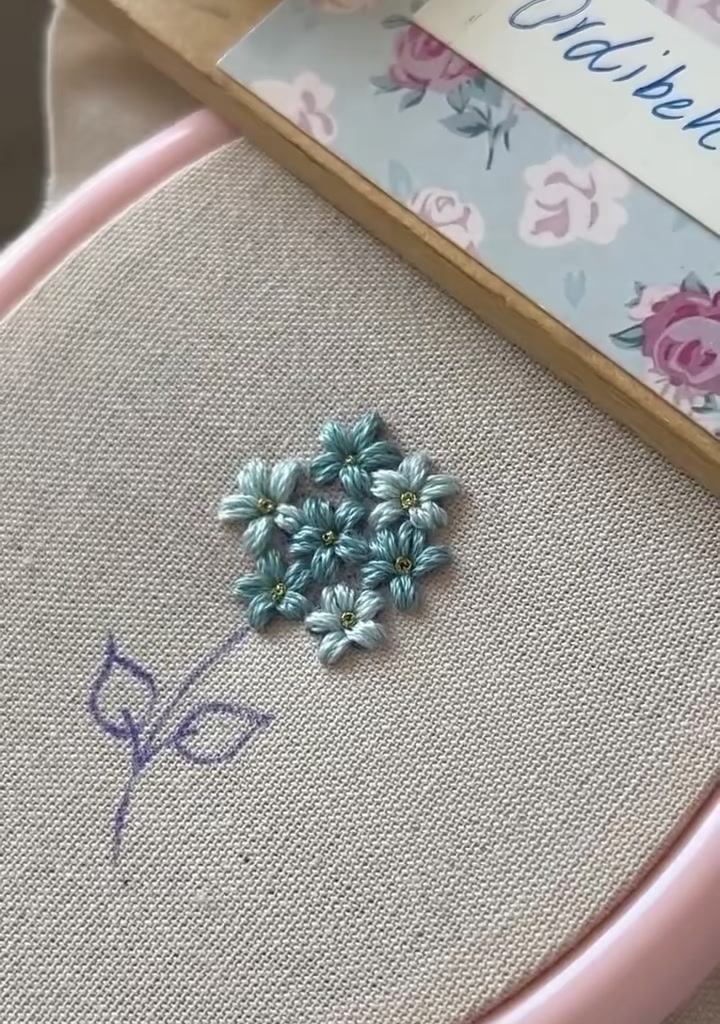 Finished embroidery with green stem and leaves added beneath the flower cluster